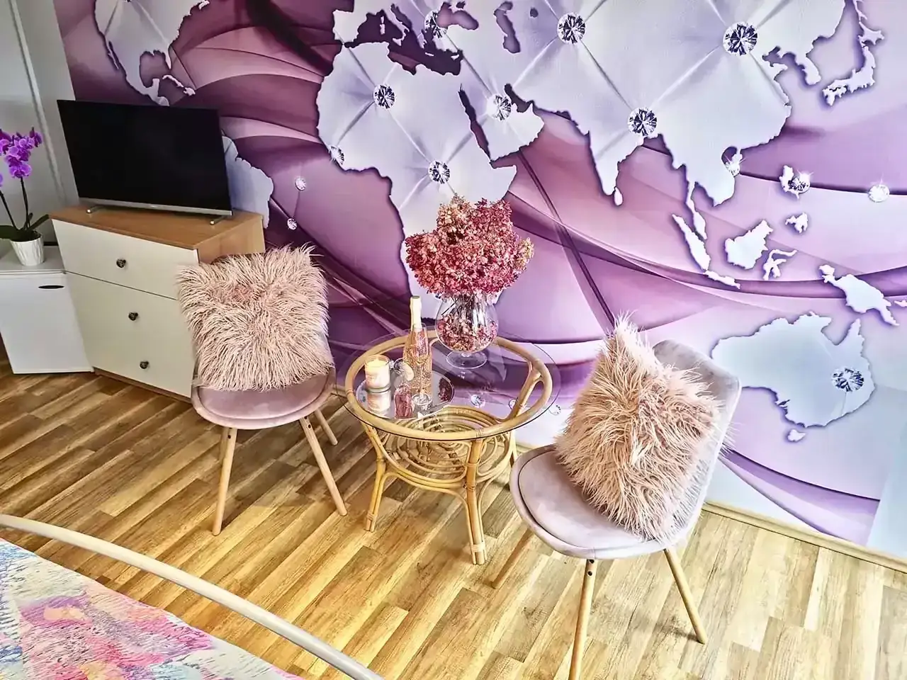 Růžový pokoj — křesílka u stolku s tapetou s mapou světa